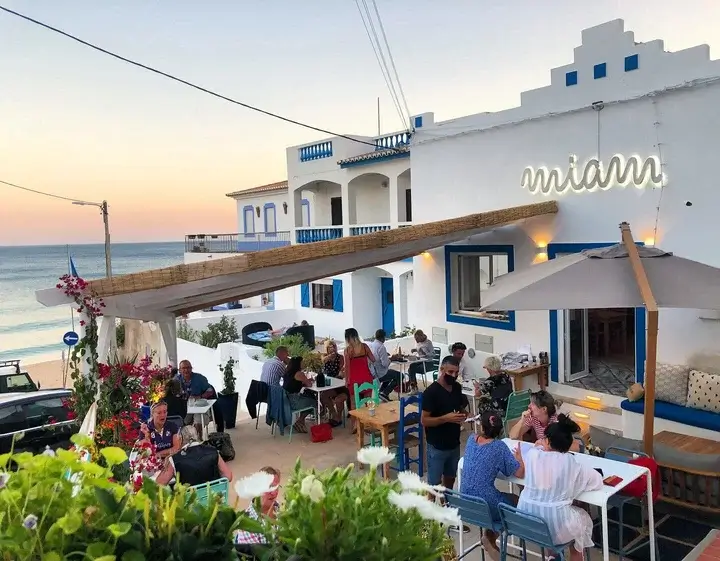 The iconic beachfront facade of Boia Bar restaurant overlooking Salema beach sands