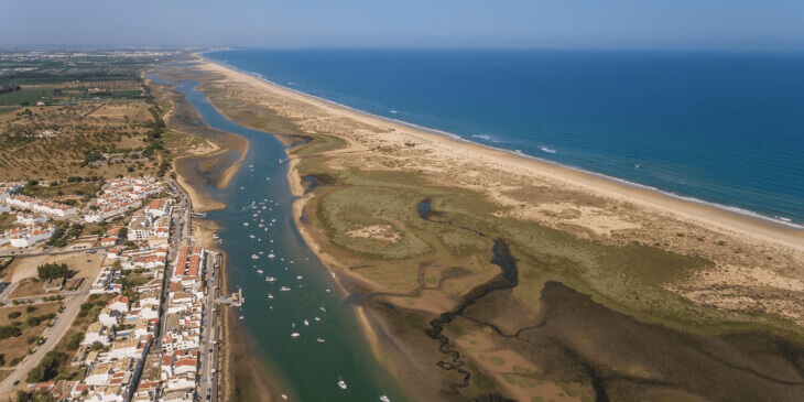 Aerial drone shot looking over the houses, lagoons, salt marshes and waterfront area of Cabanas de Tavira
