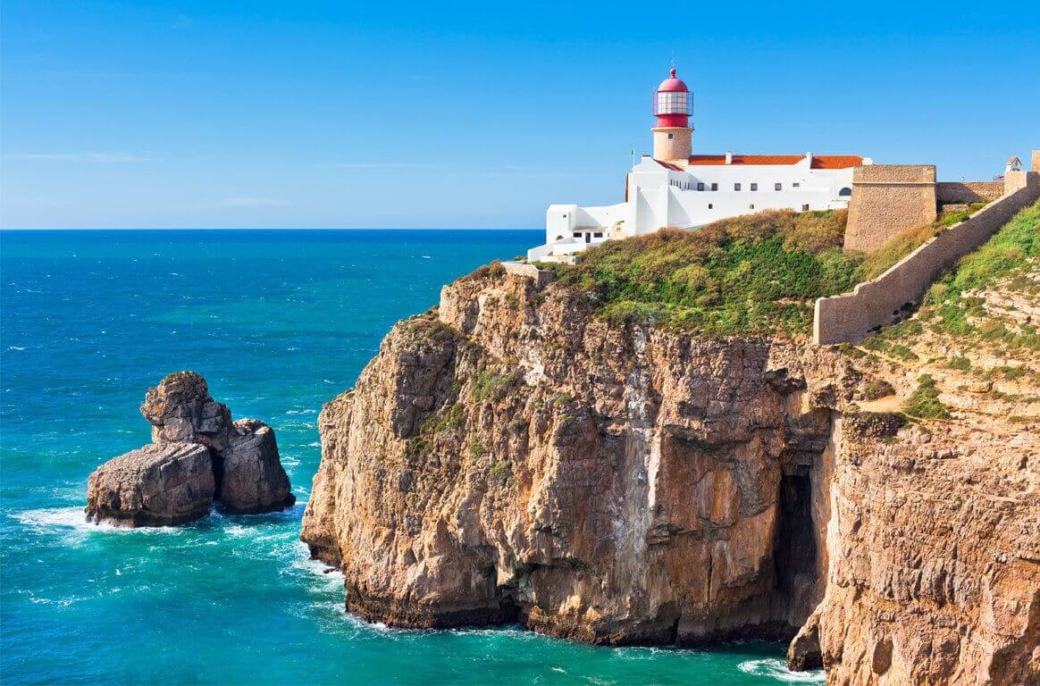 The iconic red-domed lighthouse towering over the sheer sea cliffs of Cape St. Vincent, the southwestern tip of mainland Europe