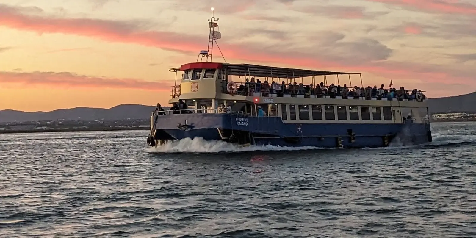 Traditional passenger ferry boat approaching the concrete jetty to transport holidaymakers out to Culatra or Armona sandbar islands