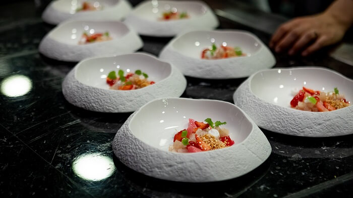 Elegant fine dining interior tables and sophisticated ambient lighting at the Michelin-starred Gusto restaurant