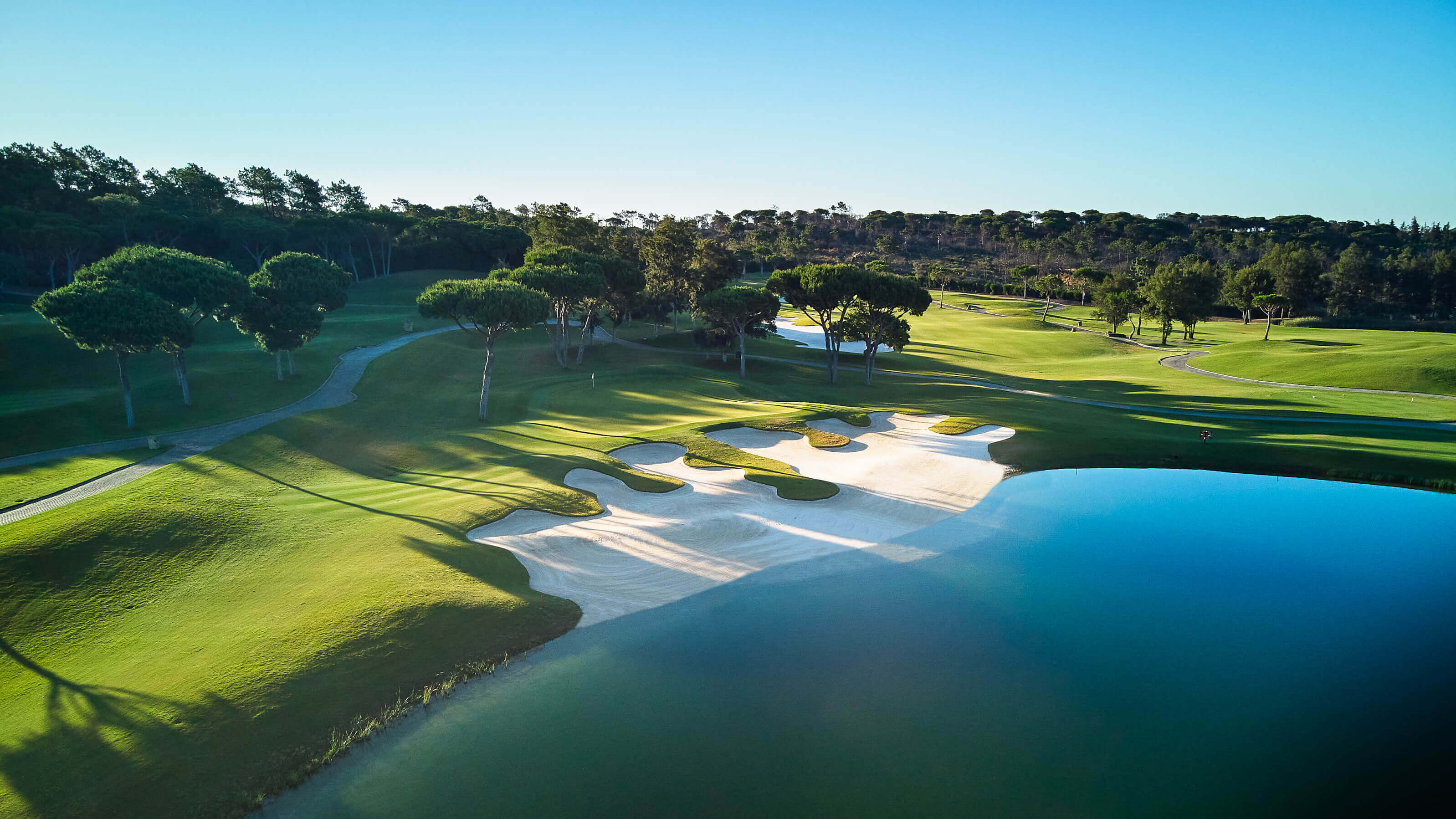 Sunlit fairways and manicured greens at Laranjal Golf Course in Quinta do Lago