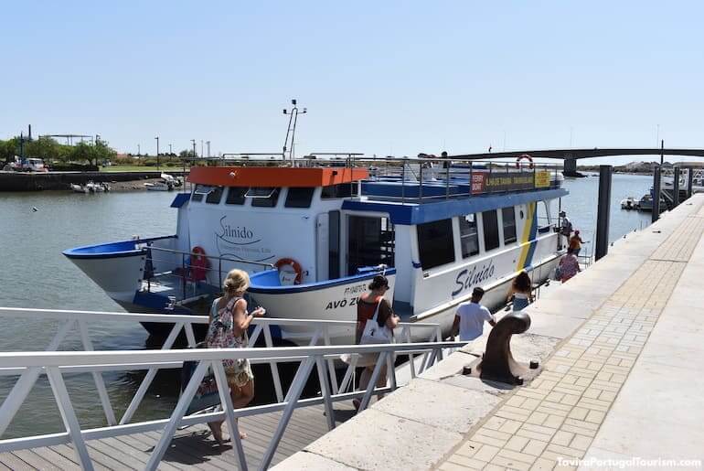 The local ferry terminal pier boarding passengers onto shuttle boats crossing the lagoon waters to the golden beaches of Tavira Island