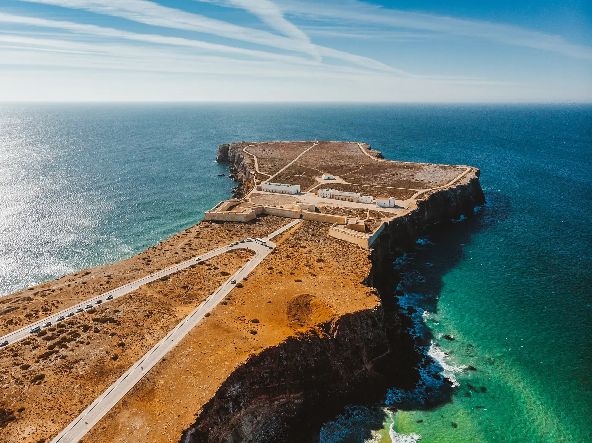 The historical coastal stone walls of the Sagres Fortress enclosing the Church of Our Lady of Grace under a clear blue sky