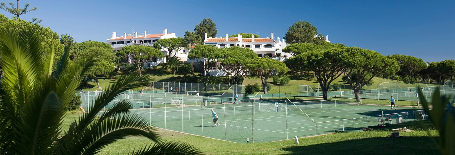 The modern, professional tennis facilities and courts of Vale do Lobo Tennis Academy under clear skies